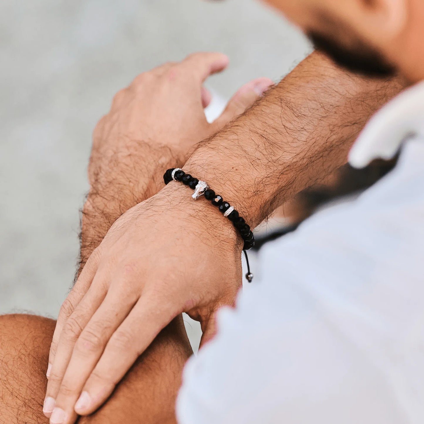 Man wearing brown tiger eye beaded bracelet with black adjustable cord by GT Collection