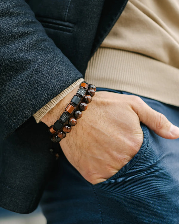 Tiger eye beaded bracelet on wrist with red and black beads and braided cord