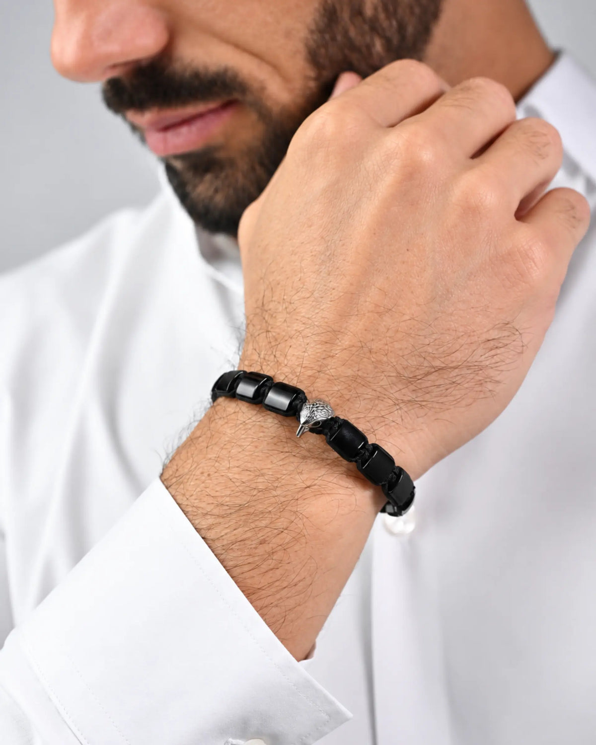 Black beaded bracelet with silver centerpiece worn on wrist