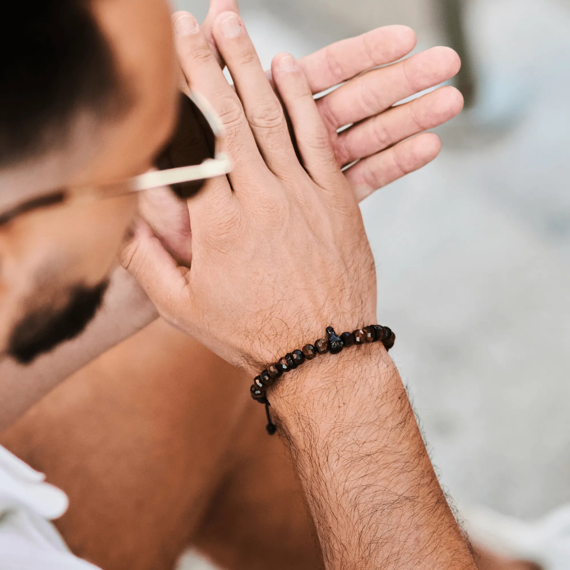 Man wearing brown tiger eye beaded bracelet with black adjustable cord by GT Collection