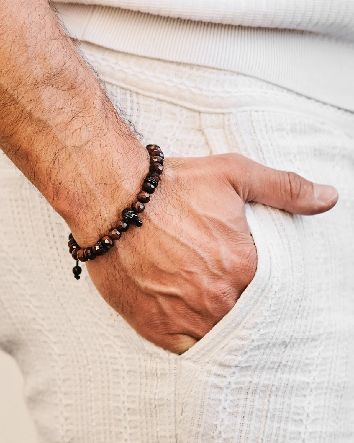 Beaded bracelet on wrist with black beads and small red-orange accent beads