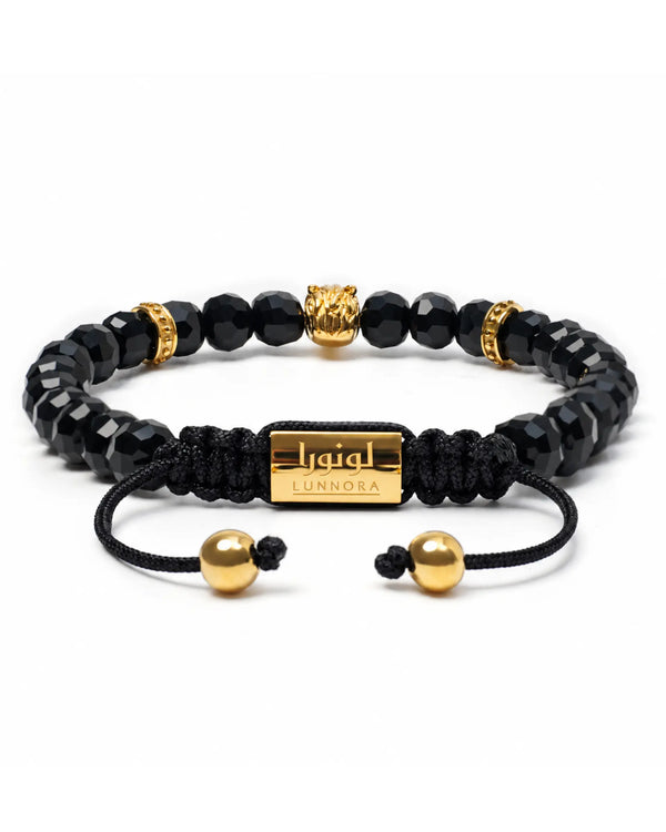 Black onyx beaded bracelet with gold-toned end caps and central horse charm on cord