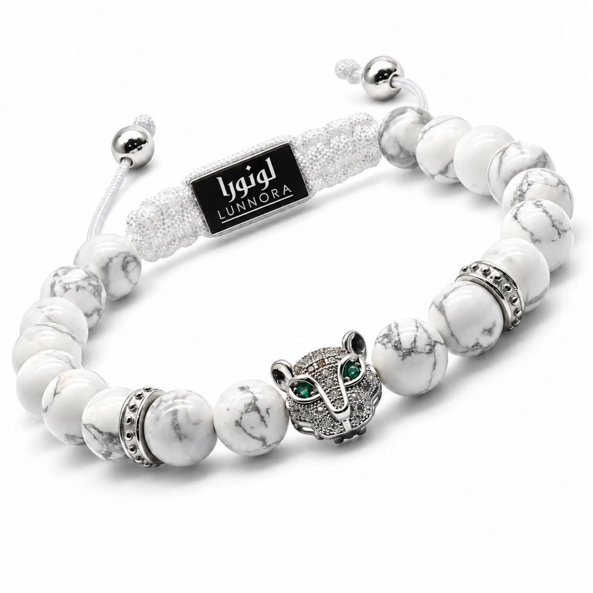 White howlite bead bracelet with silver elephant charm and green eye, logo plate.