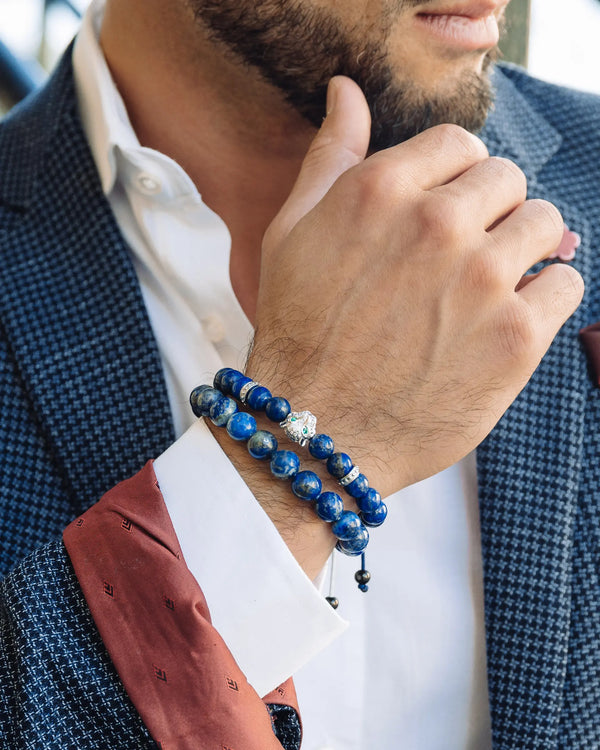 Two blue lapis lazuli bead bracelets on a man’s wrist with elephant charm