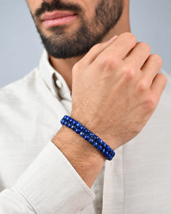 Double-row blue bead bracelet with knotted cord, worn on wrist