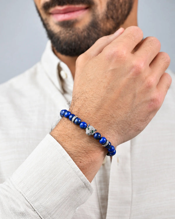 Blue bead bracelet on wrist with silver charm and clasp near hand
