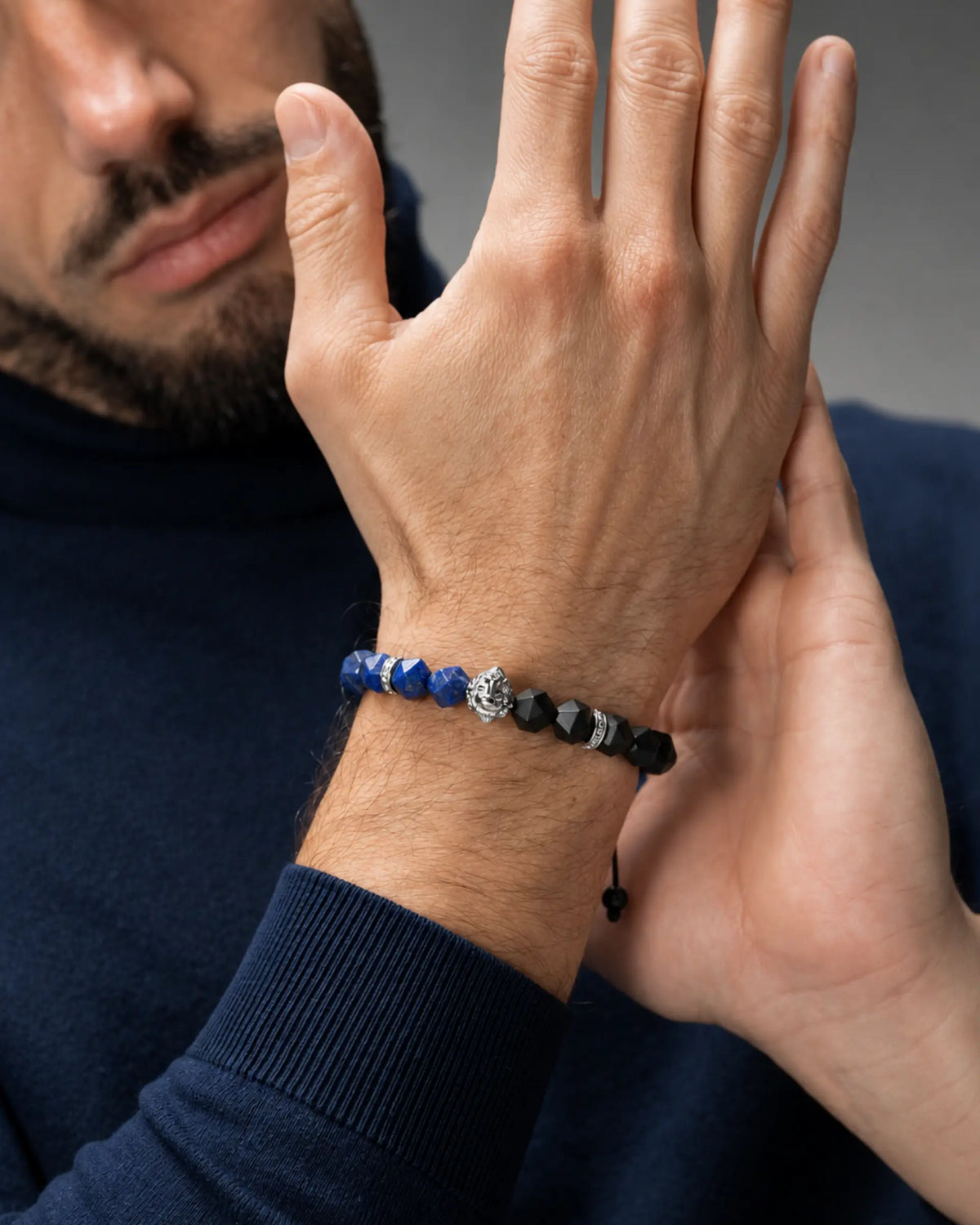 Bracelet worn on wrist: blue lapis lazuli beads with black onyx cubes and silver details