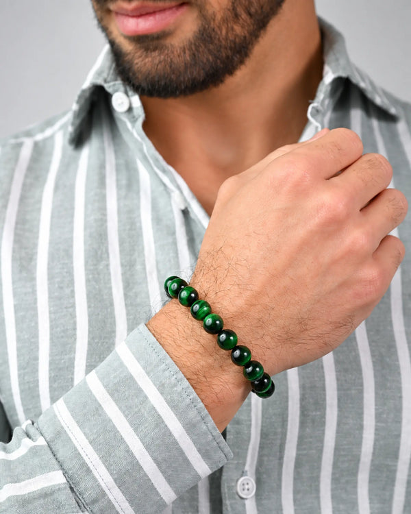 Single-row green stone bracelet on wrist with adjustable black cord
