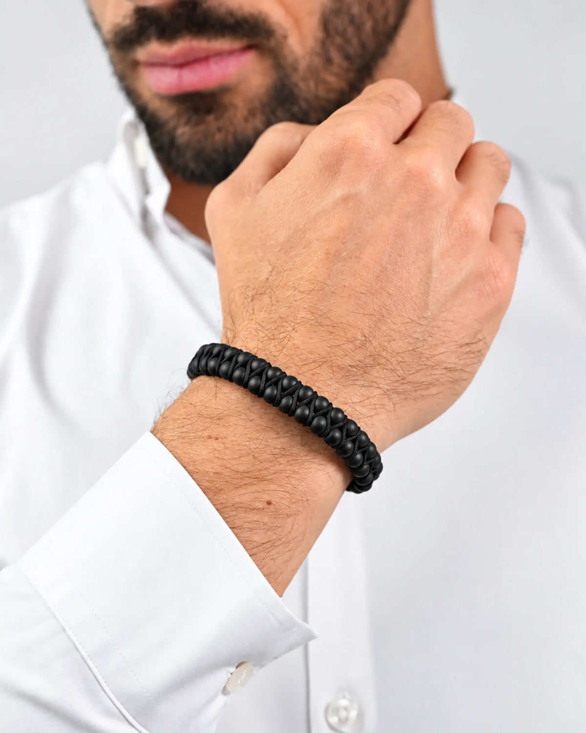 Black double-row bead bracelet with braided leather wrap on wrist