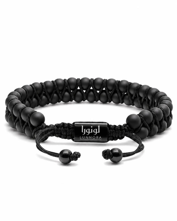 Black double-row bead bracelet laid flat with cord and metal tag