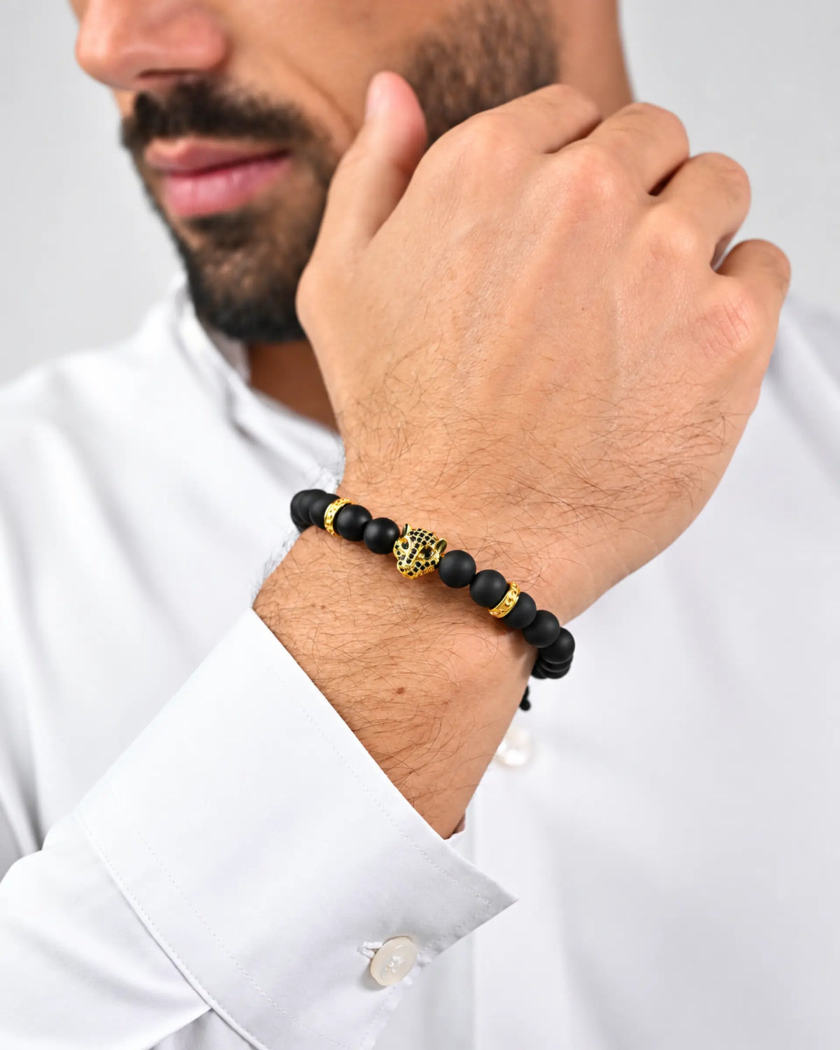 Black onyx bead bracelet with gold accents on wrist
