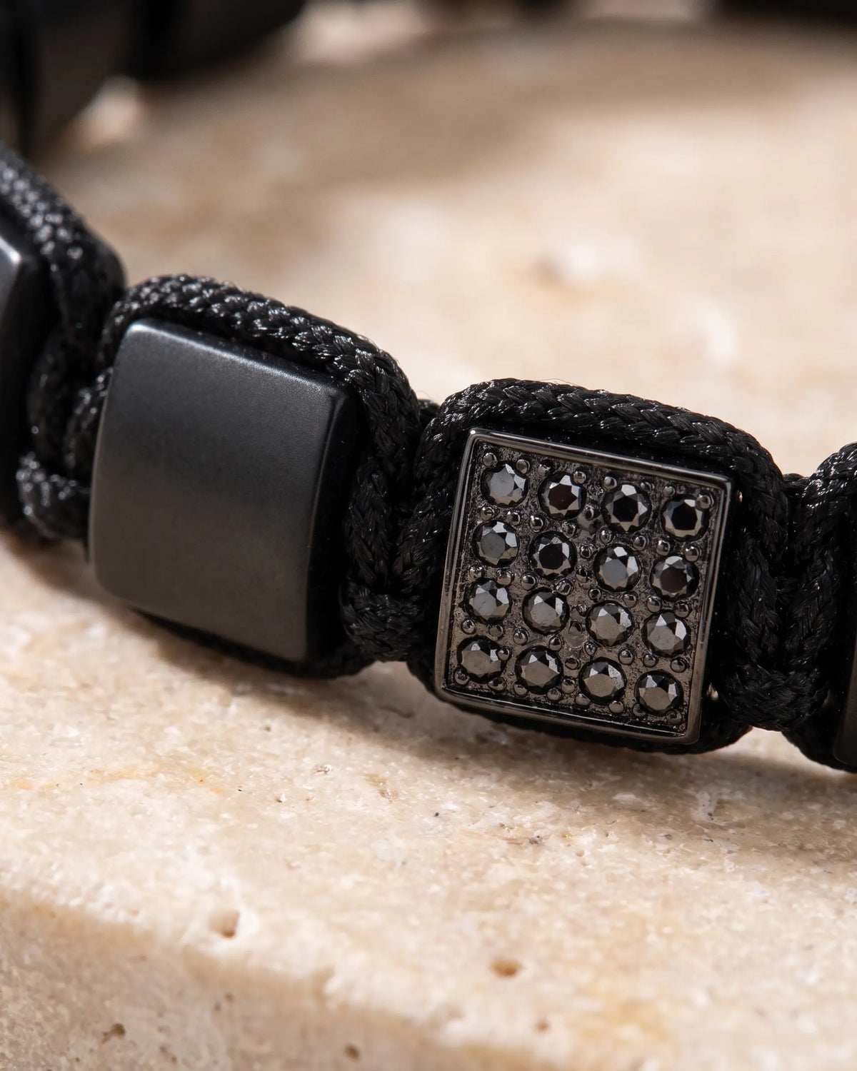 Black onyx flat bead bracelet with square center featuring dark stone detail