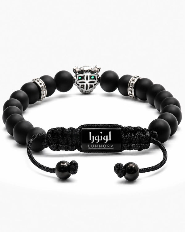 Black bead bracelet with silver-tone centerpiece charm, green accents, and LUNNORA label
