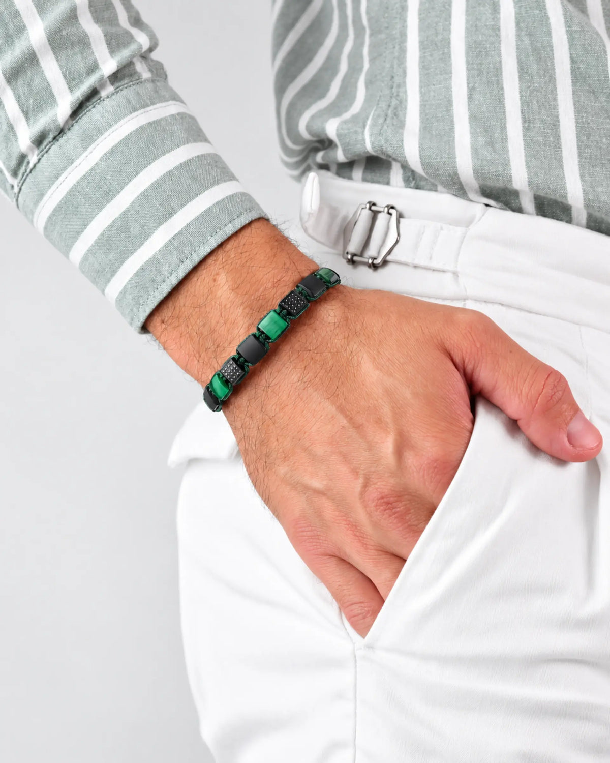 Green tiger-eye and black onyx flat bead bracelet on wrist, adjustable cord